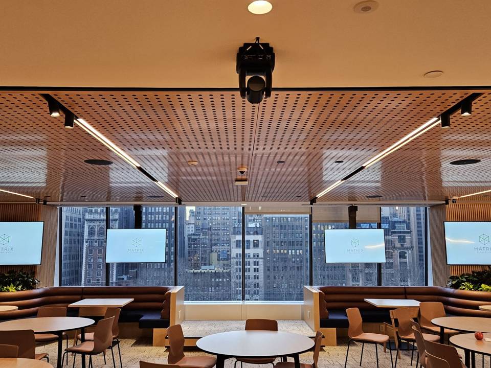 Amenity lounge with ceiling projector and wall displays above banquette seating