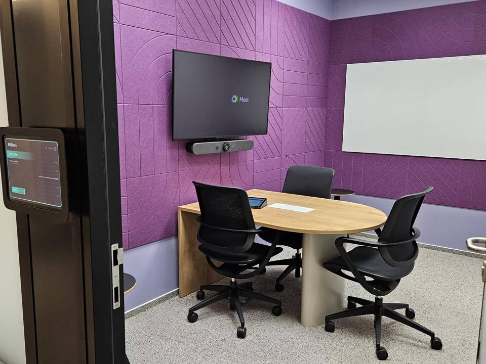 Huddle room with display, video bar and door-mounted scheduling panel